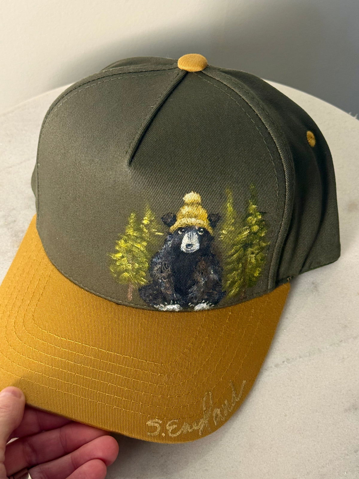 Hand painted wearable art on green canvas baseball hat with yellow brim - black bear
