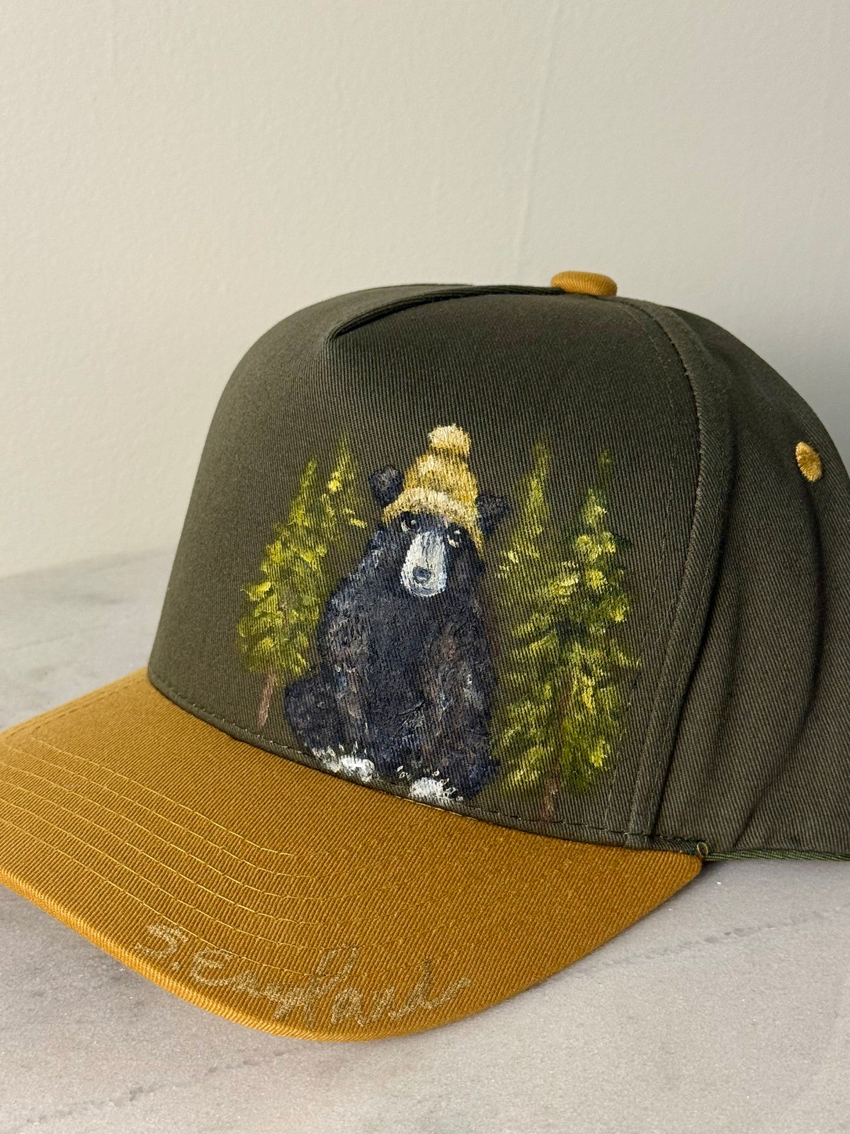 Hand painted wearable art on green canvas baseball hat with yellow brim - black bear